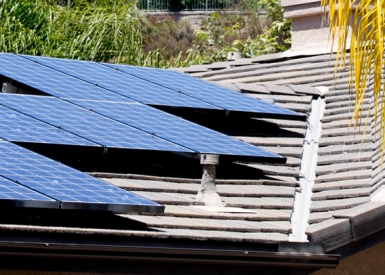 Person installing solar panels on rooftop