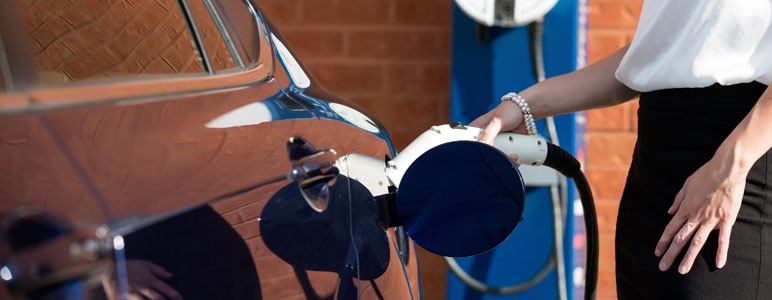 Person putting charging plug into electric vehicle